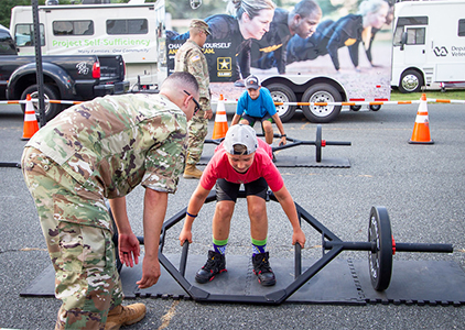 A boy trying out a barbell