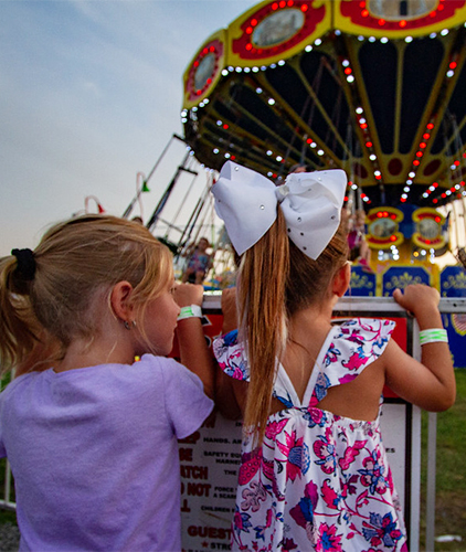 Two girls watch the swings.